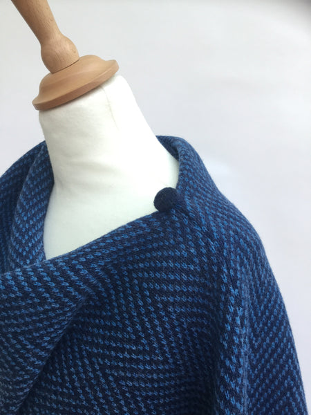 close up of button on herringbone knitted poncho