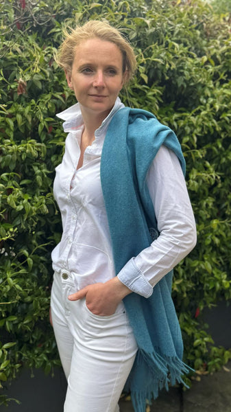Ocean blue merino wool poncho worn over the shoulder