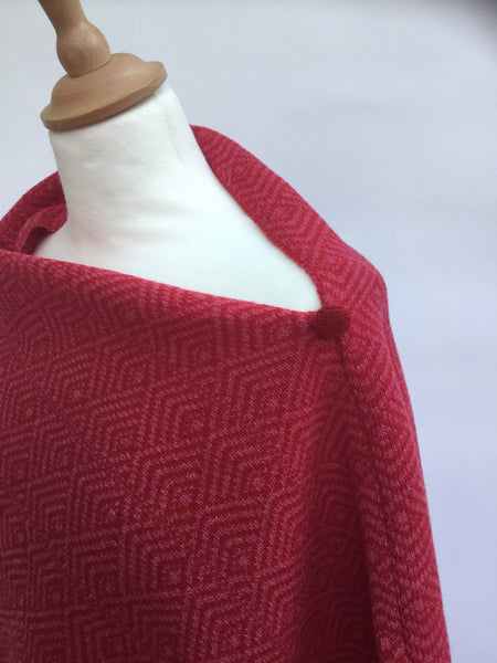 close up of button on herringbone designed poncho